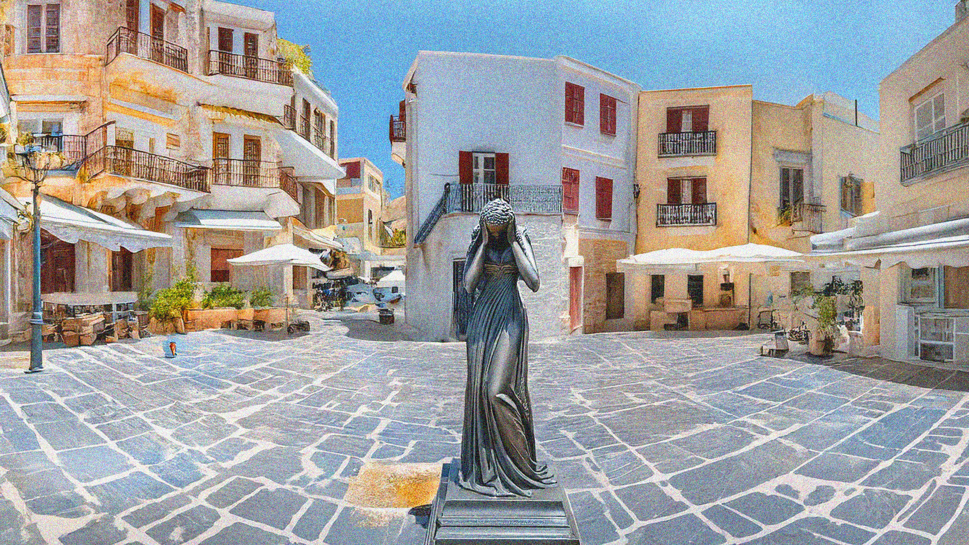 Posąg kobiety zasłaniającej twarz stoi na środku pustego placu otoczonego śródziemnomorską zabudową z białymi i pastelowymi budynkami, w słoneczny dzień.